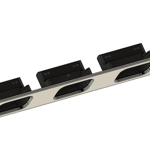 Puede incluir: Un soporte de montaje rectangular plateado con tres componentes rectangulares negros adjuntos. El soporte tiene tres recortes ovalados y varios agujeros pequeños. Los componentes parecen estar diseñados para sujetar otros objetos.