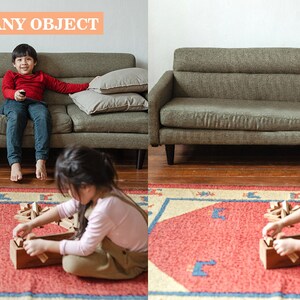 May include: Two children playing with wooden blocks on a red and blue rug in a living room. A green sofa is in the background.