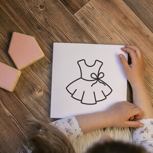 Pu&ograve; includere: Un disegno in bianco e nero di un vestito con un fiocco sul corpetto. Il disegno &egrave; su una carta bianca.