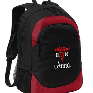 May include: Black and red backpack with a red medical symbol and the text "RN Anna" embroidered on the front.