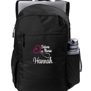 May include: Black backpack with a zippered pocket featuring a pink heart with a stethoscope and the text "Future Nurse Hannah".