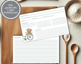 Puede incluir: Tarjetas de recetas blancas con espacios con líneas para detalles de la receta, con una bicicleta de acuarela con una cesta de flores. Las tarjetas están sobre una tabla de cortar de madera con cucharas de madera y un cuenco de harina. El texto en la tarjeta dice "PDF 4x6 RECIPE CARD DOWNLOAD".