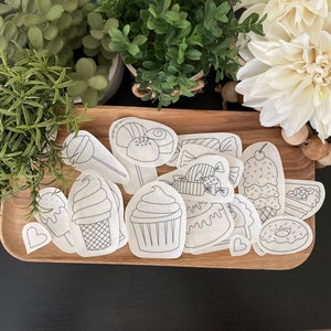 May include: A set of 14 black and white printable coloring pages featuring various sweet treats, including cupcakes, ice cream cones, lollipops, candy, and donuts.