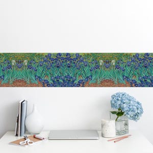 Puede incluir: Un borde decorativo con una pintura de iris azules con hojas verdes y una base marrón. La obra de arte es una vibrante exhibición de belleza floral, perfecta para agregar un toque de arte a cualquier espacio. El borde se muestra en una pared blanca.