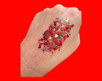 Könnte beinhalten: Roter, grüner und silberner Glitzer in Form von Herzen und Mickey-Maus-Köpfen auf einer Hand.