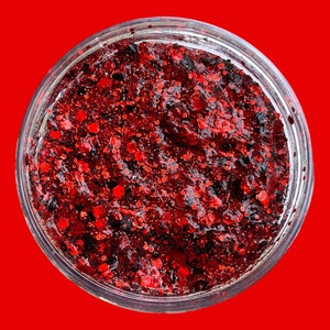 May include: A clear jar filled with red glitter glue. The glitter is a mix of red and black.