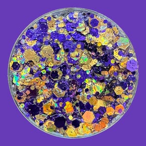 May include: A close-up of a jar filled with iridescent glitter in shades of gold and purple.
