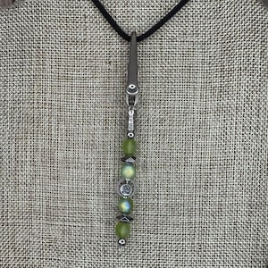 May include: A silver key chain with a green glass bead charm and a silver charm with the number "29" on it.