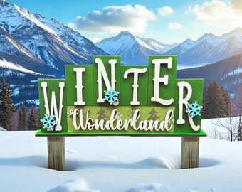 May include: A green wooden sign with the words "WINTER Wonderland" in white lettering, decorated with blue snowflake accents. The sign is set in a snowy landscape with mountains in the background.
