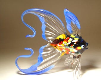 Figura artística de vidrio soplado hecha a mano: pez azul y transparente con cola arqueada.