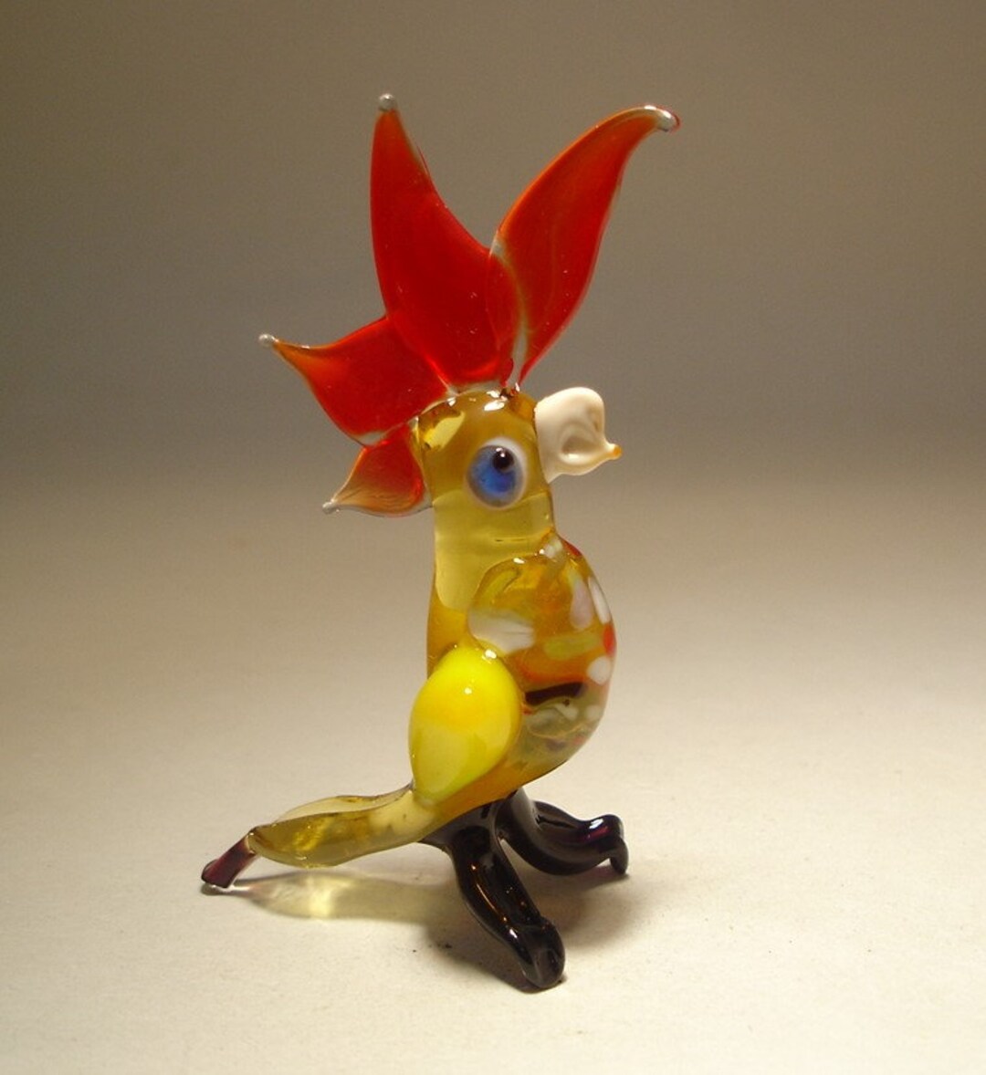吹きガラスのオウムの置物：小さな手作りの黄色い赤い紋のオウム