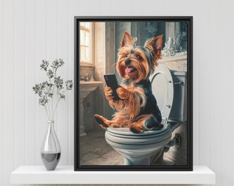 May include: A brown and black Yorkshire Terrier dog sits on a white toilet, holding a smartphone in its paws. The dog is in a bathroom setting with a window and a sink in the background.