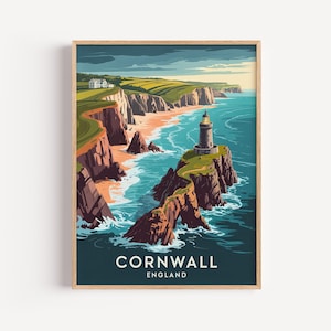 May include: A framed art print featuring a coastal landscape of Cornwall, England. The artwork depicts a lighthouse on a rocky cliff, with the text "Cornwall England" at the bottom. The scene includes a beach, ocean, and rolling green hills.
