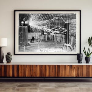 Könnte beinhalten: Ein modernes Wohnzimmer mit einem großen, gerahmten Schwarz-Weiß-Foto eines wissenschaftlichen Experiments. Das Foto hängt über einem Holzschrank mit dekorativen Gegenständen und Topfpflanzen. Im Vordergrund befindet sich ein gelbes Sofa mit einem gemusterten Kissen.