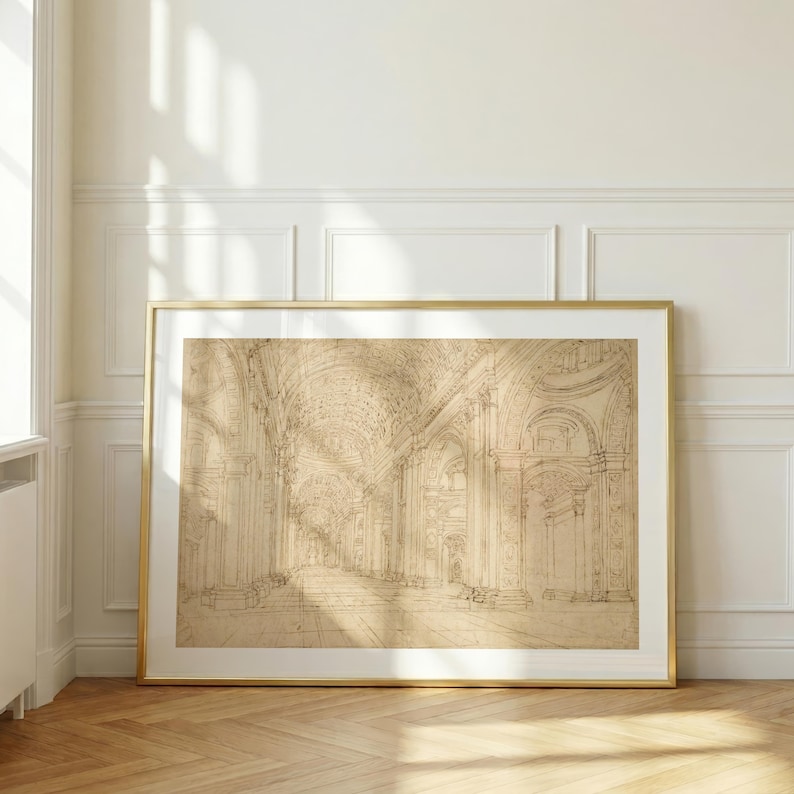 Op de afbeelding: Een ingelijste architectuurschets in een gouden lijst. De sepia-getinte tekening toont een gedetailleerd interieur met bogen, zuilen en een lange gang. Het kunstwerk wordt tentoongesteld tegen een witte muur met lijstwerk en een houten vloer.