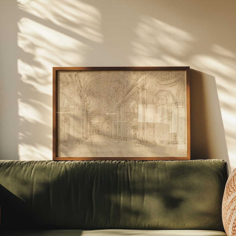 Op de afbeelding: Een ingelijste architectuurschets in een warmbruine houten lijst. De schets toont een lang, gewelfd interieur met gedetailleerde bogen en kolommen. Het kunstwerk wordt tentoongesteld boven een groene fluwelen bank, met schaduwen van zonlicht.