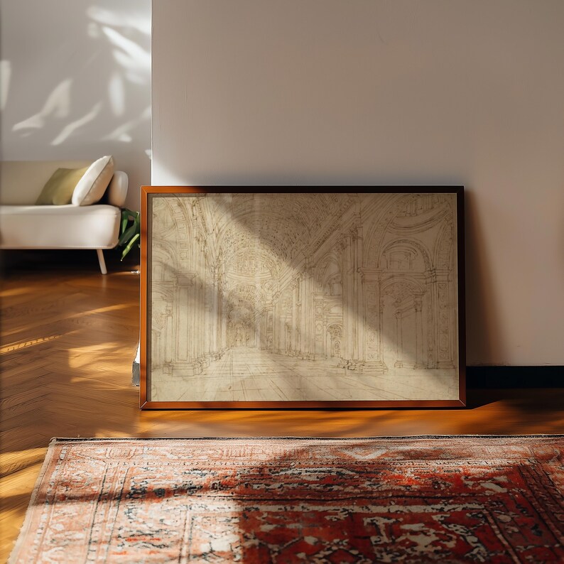 Op de afbeelding: Een ingelijste architectuurschets in een warmbruine houten lijst. De schets toont een gedetailleerd interieur met bogen en zuilen. Het kunstwerk wordt tentoongesteld op een houten vloer, met een patroonkleed op de voorgrond.