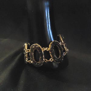 Peut inclure: Un bracelet dor&eacute; avec un design de cha&icirc;ne et des maillons ovales. Les maillons sont textur&eacute;s et ont une finition martel&eacute;e.