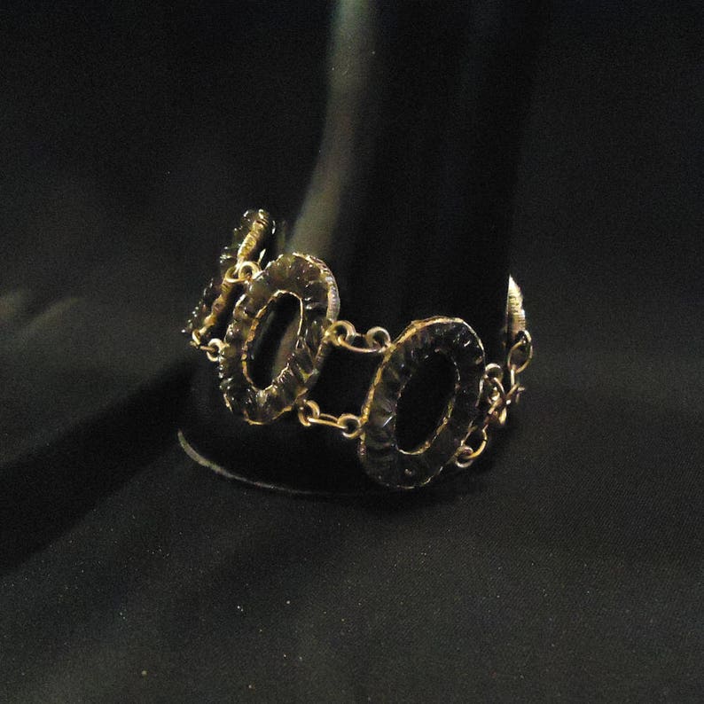 Peut inclure: Un bracelet en or avec des maillons de forme ovale. Les maillons sont textur&eacute;s et ont une finition martel&eacute;e.