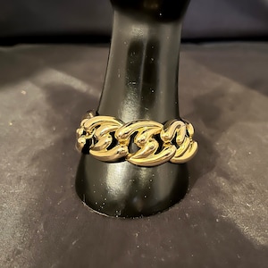 May include: A gold-toned chain link bracelet with a chunky design.