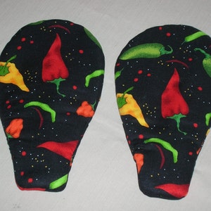 May include: Two oven mitts with a black background, patterned with colorful chili peppers. The peppers are red, green, yellow, and orange, with white speckles. The mitts are designed to protect hands from heat.