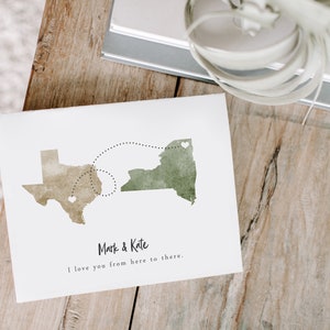 May include: A watercolor print of the states of New York and Texas with a dotted line connecting them. The print has the text "Mark & Kate" and "I love you from here to there."