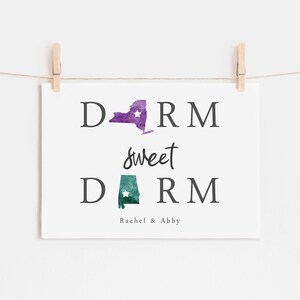 May include: A white print with the text "Dorm sweet Dorm" with a purple outline of New York and a green outline of Alabama. The text "Rachel & Abby" is below the states.