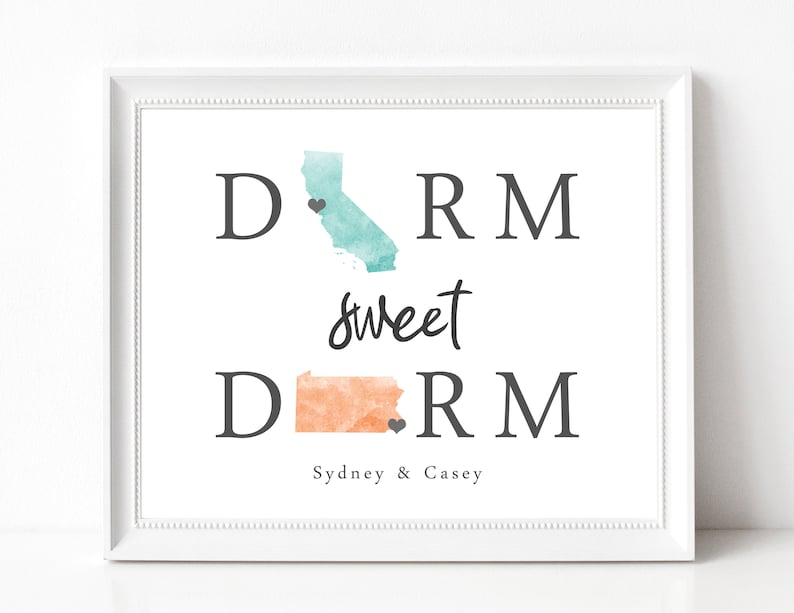 May include: A white framed print with the text "Dorm sweet dorm" in black lettering. The print features watercolor outlines of California and Pennsylvania with hearts marking the locations of Sydney and Casey.