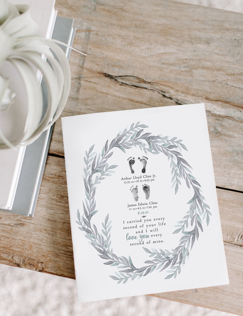 May include: A watercolor print with a wreath of leaves and two sets of baby footprints. The print includes the names Arthur Lloyd Cline Jr., 12.25 oz 10 in 6:53 pm, James Edwin Cline, 11 oz 9.5 in 7:01 pm, 8.26.91, and the text "I carried you every second of your life and I will love you every second of mine."