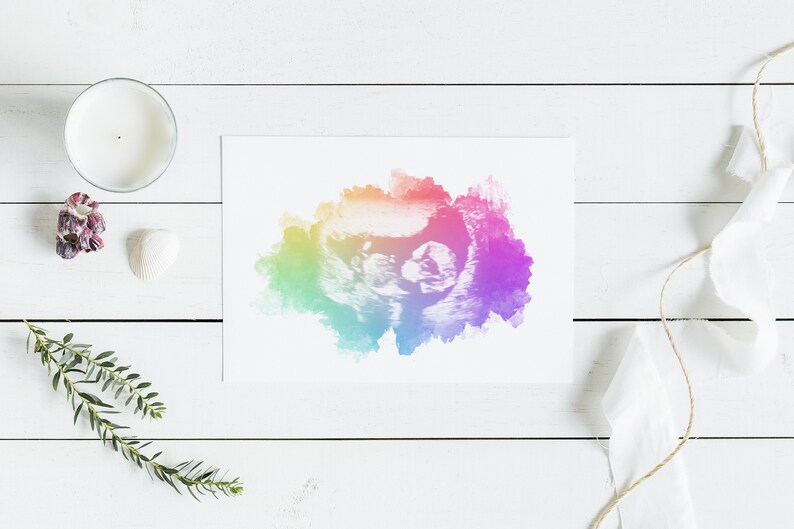 K&ouml;nnte beinhalten: Ein regenbogenfarbener Aquarelldruck eines Ultraschallbildes. Der Druck ist auf wei&szlig;em Hintergrund und von wei&szlig;em Holz umgeben.