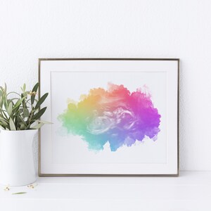 K&ouml;nnte beinhalten: Ein gerahmter Druck eines farbenfrohen abstrakten Aquarellbildes. Das Bild zeigt eine gro&szlig;e, wolkenartige Form in Rot-, Orange-, Gelb-, Gr&uuml;n-, Blau- und Violettt&ouml;nen.