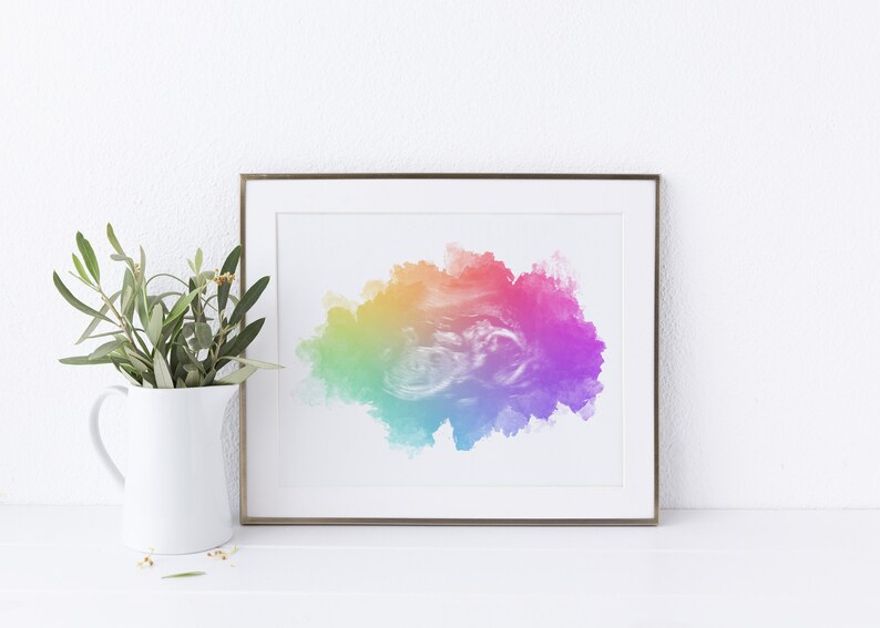 K&ouml;nnte beinhalten: Ein gerahmter Druck eines farbenfrohen abstrakten Aquarellbildes. Das Bild zeigt eine gro&szlig;e, wolkenartige Form in Rot-, Orange-, Gelb-, Gr&uuml;n-, Blau- und Violettt&ouml;nen.