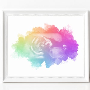 K&ouml;nnte beinhalten: Ein Regenbogen-Aquarellhintergrund mit einem Schwarzwei&szlig;-Ultraschallbild eines Babys in der Mitte.