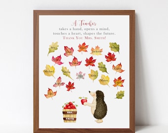 May include: A framed print with a fall-themed design. The print features a hedgehog holding an apple and a basket of apples. The text "A Teacher takes a hand, opens a mind, touches a heart, shapes the future. Thank You Mrs. Smith!" is printed at the top of the print. The names of students are printed on colorful leaves around the hedgehog.