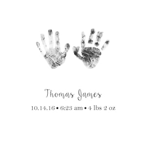 May include: Black and white handprint art with the name Thomas James and the date 10.14.16, 6:23 am, and weight 4 lbs 2 oz.