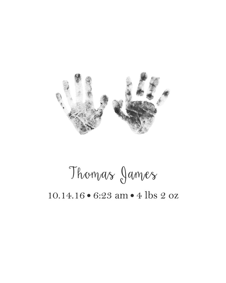 May include: Black and white handprint art with the name Thomas James and the date 10.14.16, 6:23 am, and weight 4 lbs 2 oz.
