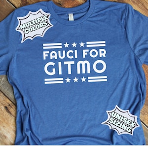 May include: A blue t-shirt with the text "Fauci for Gitmo" in white letters. The shirt has a red, white, and blue star design. The shirt is available in multiple colors and unisex sizing.