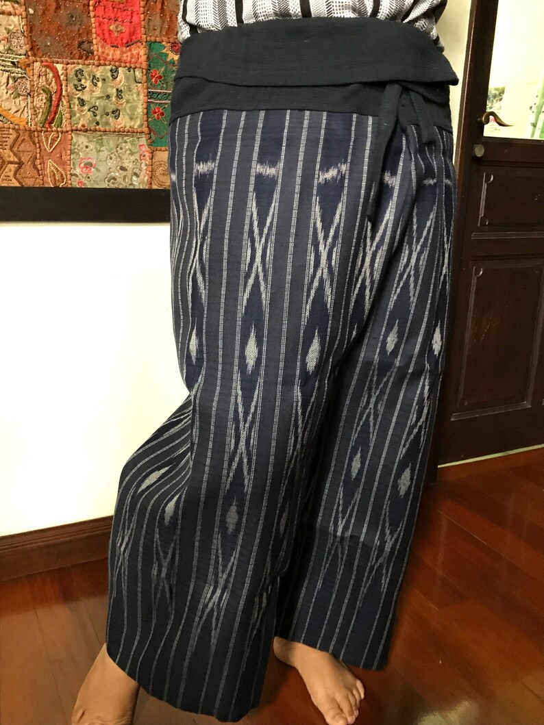 Pu&ograve; includere: Un paio di pantaloni a righe blu e bianche con un motivo geometrico. I pantaloni sono legati in vita con una fascia blu scuro.