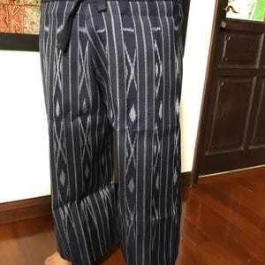 Pu&ograve; includere: Pantaloni blu e bianchi con motivo, con una cintura larga e chiusura a cravatta. I pantaloni sono realizzati in un tessuto morbido e leggero e hanno una vestibilit&agrave; rilassata.