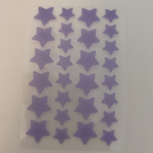 May include: A sheet of purple star-shaped stickers in various sizes. The stickers are arranged in rows and columns on a clear backing. The stars have a soft, matte finish.