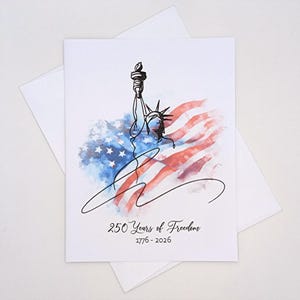 May include: A white greeting card with a watercolor illustration of the Statue of Liberty and the American flag. The card features the text "250 Years of Freedom 1776-2026" in a handwritten font. The card is paired with a white envelope.