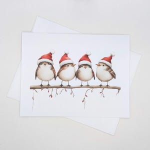 May include: A watercolor illustration of four small birds perched on a branch. Each bird wears a red Santa hat with a white pom-pom. The birds have brown and white feathers and are set against a white background.