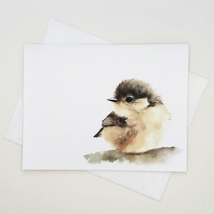May include: Watercolor illustration of a small bird with brown and tan feathers, perched on a branch. The bird is depicted on a white card, with a white envelope in the background. The artwork has a soft, natural aesthetic.