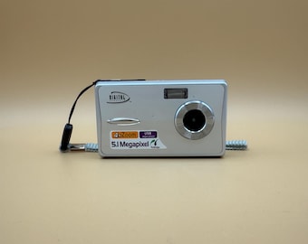 Fotocamera Digital Concepts da 5,1 megapixel, colore argento, compatibile con PictBridge, compatta e facile da usare. Include scheda SD da 2 GB. Testata e funzionante. Richiede batterie.