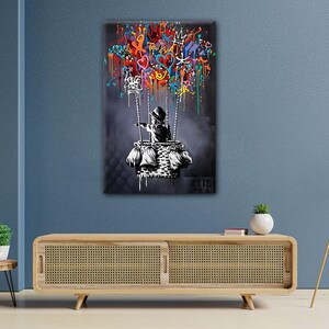 May include: A black and white illustration of a child in a hot air balloon. The balloon is filled with colourful graffiti, including hearts, crowns, and other symbols. The background is a dark grey.