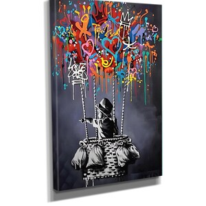 May include: A black and white illustration of a child in a hot air balloon. The balloon is filled with colourful hearts, stars, and other graffiti-style designs. The child is holding onto the basket and looking out at the viewer.