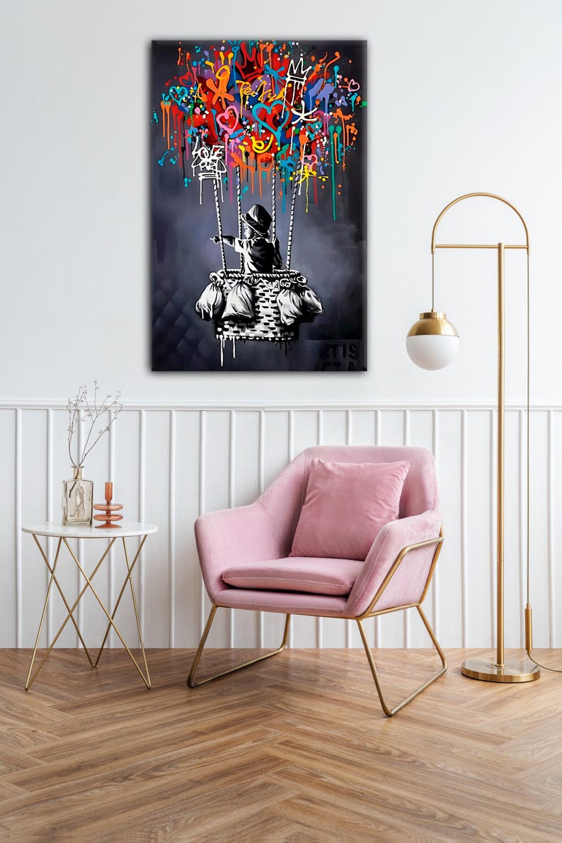 May include: A black and white illustration of a child in a basket, holding onto strings attached to a hot air balloon. The balloon is made of colourful graffiti, including hearts, crowns, and other symbols. The background is a dark blue.