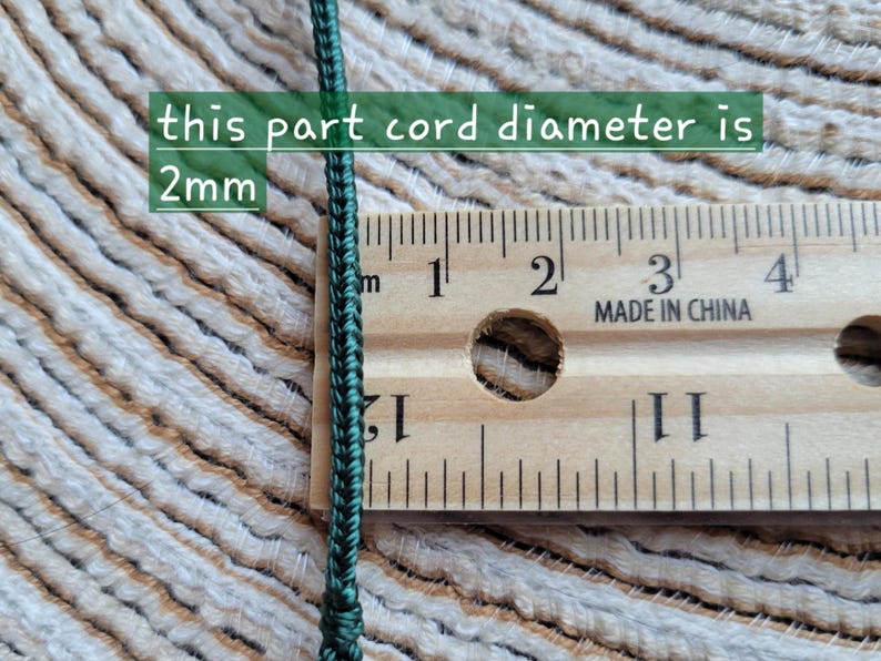 Puede incluir: Primer plano de un cord&oacute;n verde oscuro junto a una regla de madera. El texto de la imagen indica que el di&aacute;metro del cord&oacute;n es de 2 mm. La regla muestra medidas en cent&iacute;metros.