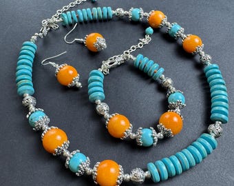 May include: A turquoise and orange beaded necklace, bracelet, and earrings set. The necklace and bracelet feature silver accents and round orange beads. The earrings are silver with a round orange bead.
