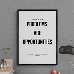 May include: A black framed motivational poster with the text "Recognize that: Problems are opportunities. Capitalize on the value solving the problem will bring."